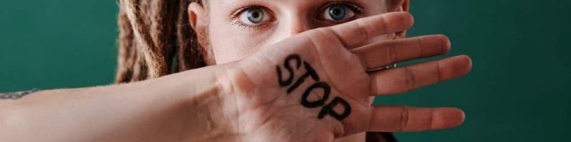 בחורה אשר עברה הטרדה מינית עם כיתוב על היד של "עצור"